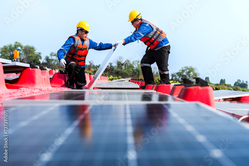 Photovoltaic engineers work on floating photovoltaics. workers Inspect and repair the solar panel equipment floating on water. Engineer working setup Floating solar panels Platform system on the lake. © ultramansk
