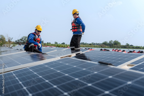 Male workers repair Floating solar panels on water lake. Engineers construct on site Floating solar panels at sun light. clean energy for future living. Industrial Renewable energy of green power.