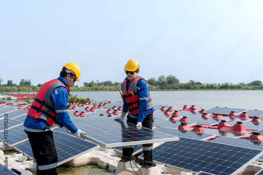 Photovoltaic engineers work on floating photovoltaics. workers Inspect and repair the solar panel equipment floating on water. Engineer working setup Floating solar panels Platform system on the lake. Photovoltaic engineers work on floating photovoltaics. workers Inspect and repair the solar panel equipment floating on water. Engineer working setup Floating solar panels Platform system on the lake.