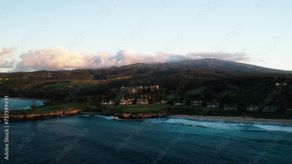 Aerial Backward Shot Of Sea By Houses On Coastline Near Mountain Against Sky At Sunset - Maui , Hawaii Aerial Backward Shot Of Sea By Houses On Coastline Near Mountain Against Sky At Sunset - Maui , Hawaii