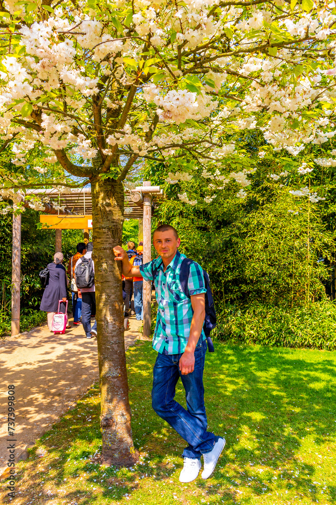 Fototapeta premium Man tourist with tulip flowers in park in Lisse Netherlands.