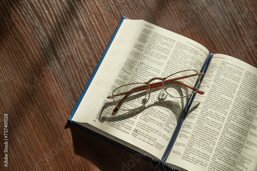 Holy Bible, eyeglasses. Lifestyle, natural aesthetic light.