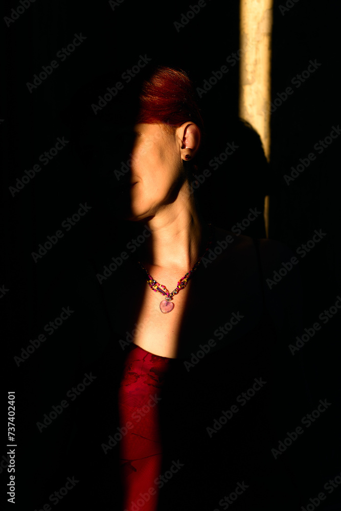 Obraz premium Close-up shot of a middle-aged woman's neck. Necklace with a heart-shaped pendant from rose quartz on the neck. Rays of the setting sun