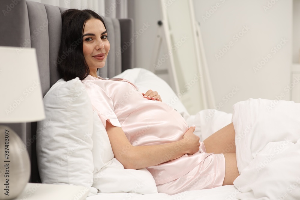Pregnant young woman in bed at home Pregnant young woman in bed at home