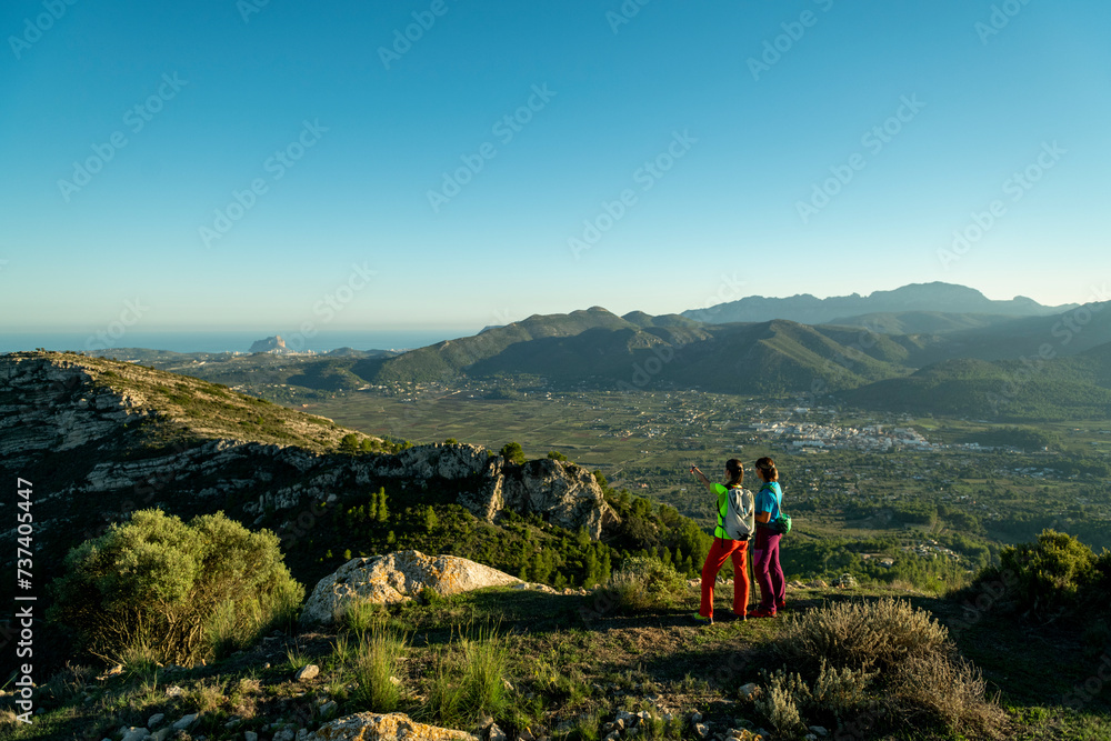 Two women hikers enjoying the beautiful nature from high above, Lliber, Alicante, Costa Blanca, Spain - stock photo