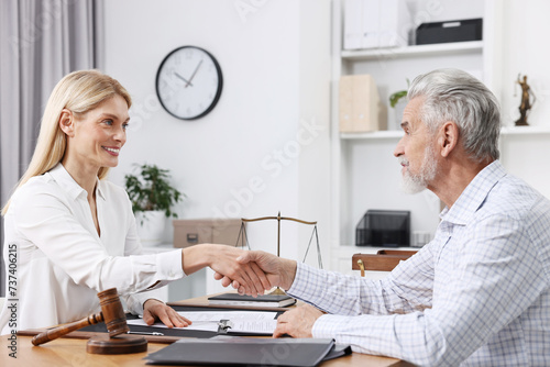 Lawyer shaking hands with client in office