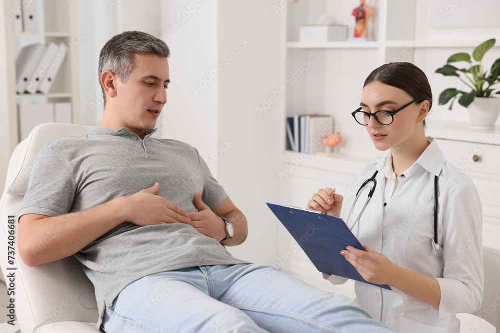 Gastroenterologist with clipboard consulting patient in clinic Gastroenterologist with clipboard consulting patient in clinic