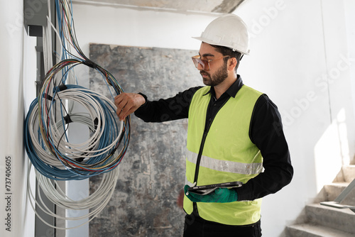 Caucasian Electrical engineer man checking wires at construction site 