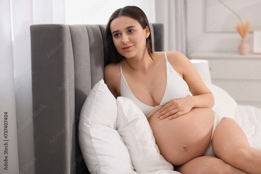 Beautiful pregnant woman in stylish comfortable underwear on bed at home Beautiful pregnant woman in stylish comfortable underwear on bed at home