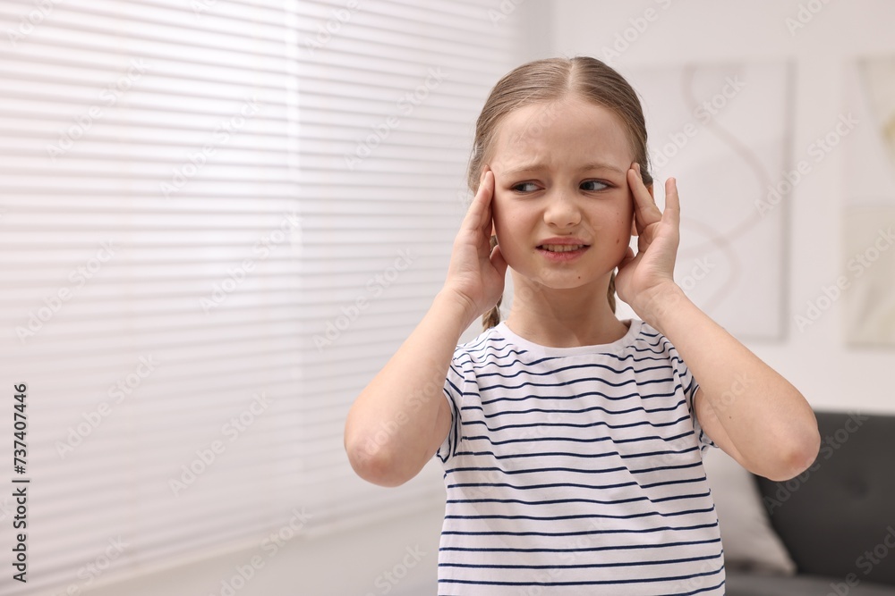 Little girl suffering from headache at home. Space for text Little girl suffering from headache at home. Space for text
