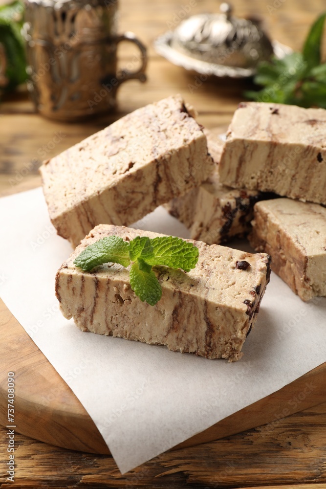Tasty chocolate halva with mint on wooden table Tasty chocolate halva with mint on wooden table
