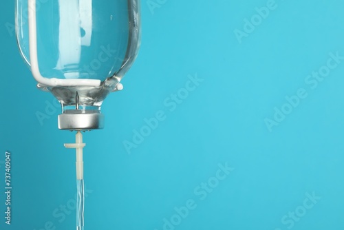 IV infusion set on light blue background, closeup. Space for text