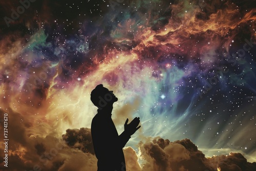 Silhouette of praying man against composite image of starry sky. Worship.