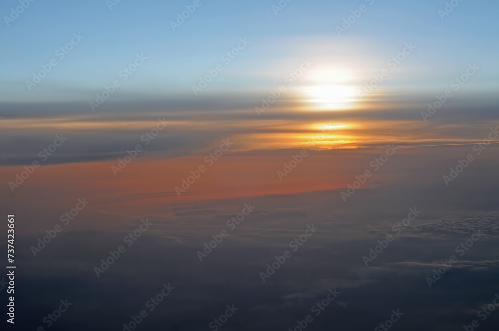 Sunset above the clouds as seen from airplane, nature background