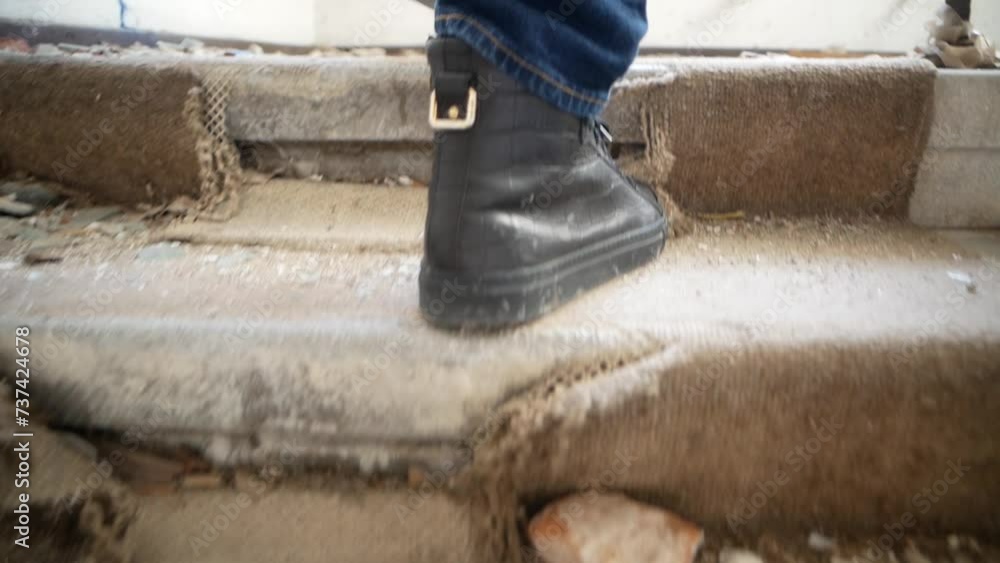 Climbing the stairs of a ruined building. Close-up of feet climbing stairs, shot from behind Climbing the stairs of a ruined building. Close-up of feet climbing stairs, shot from behind