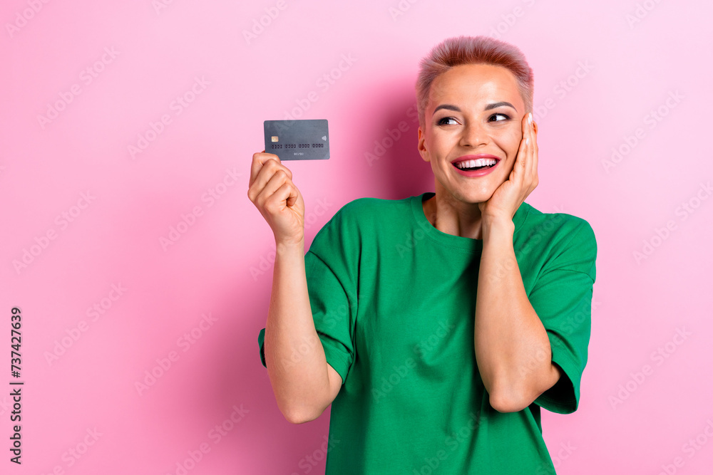 Photo of cheerful adorable cute woman wear green stylish clothes hold bank card nfc payment isolated on pink color background Photo of cheerful adorable cute woman wear green stylish clothes hold bank card nfc payment isolated on pink color background