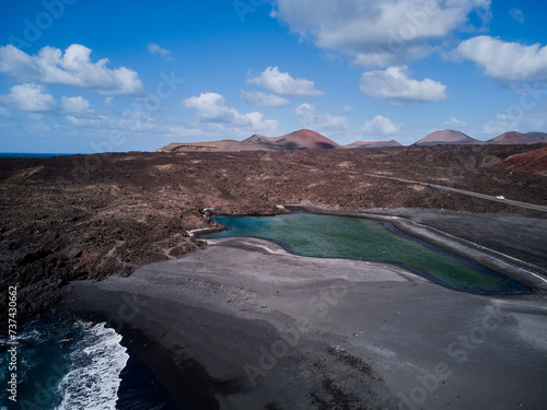 Waves and black sand beach on the shore of the Atlantic Ocean and volcano in Lanzarote Spain