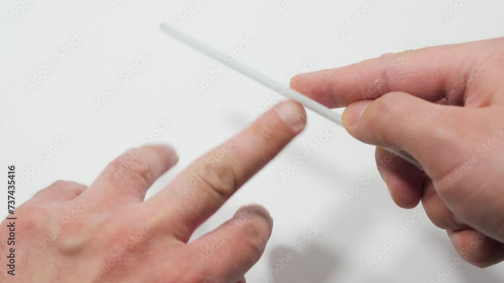 Man files nails on hands, isolated close up. Manicure. Master make nail extension. Finger closeup Man files nails on hands, isolated close up. Manicure. Master make nail extension. Finger closeup