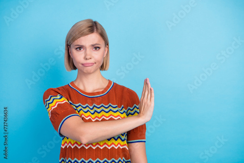 Portrait of indifferent funny girl with short hairstyle wear strited t-shirt hold palm show stop isolated on blue color background photo