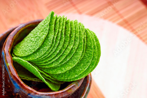 Avocado chips with bowl on blue background