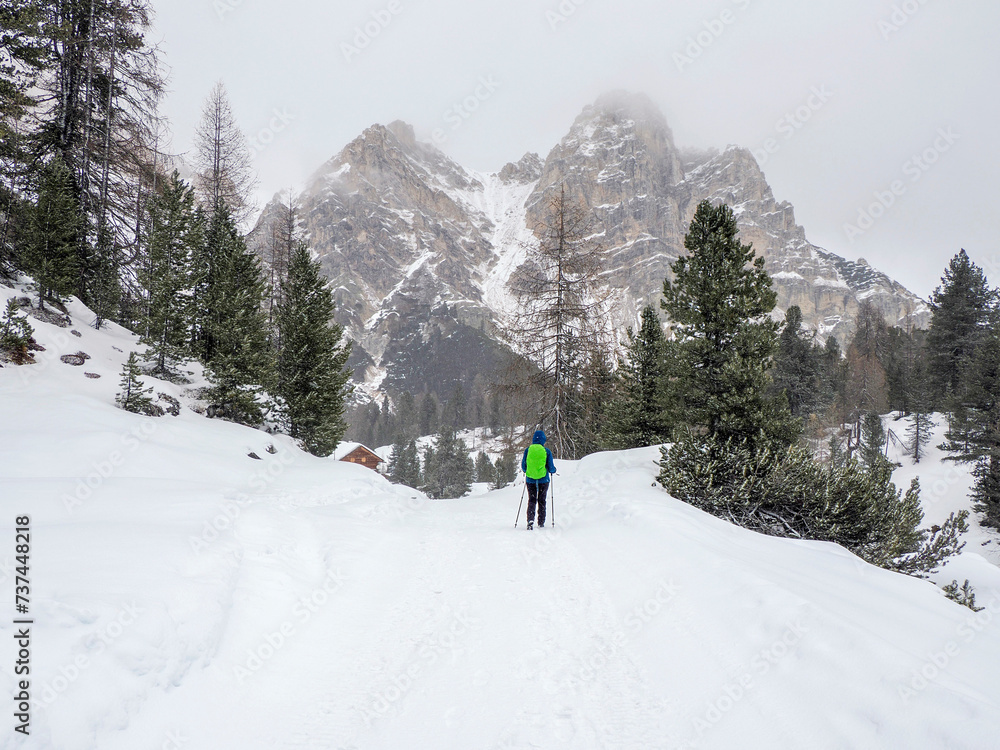 snow falling on hiker in Fanes mountain Dolomites winter panorama landscape