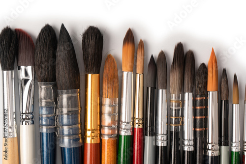 Mix of paint brushes in a row isolated on a white background.