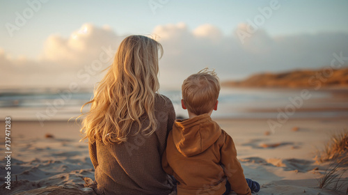 Mujer joven jugando en la playa con su hijo pequeño