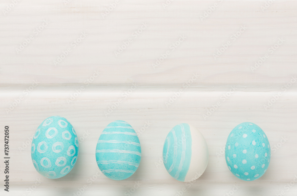 Fototapeta premium Blue easter eggs on wooden background, top view