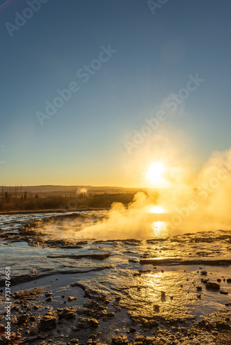 Stokkur geyser spectacular eruption in front of the sun , Iceland