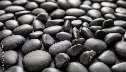 black background black pebbles of irregular shape evenly poured onto the surface monochrome photo