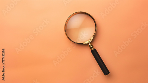 A single antique magnifying glass, placed against a muted colored background, symbolizes curiosity and discovery