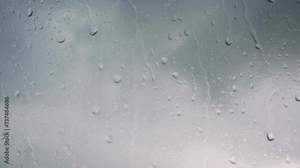 Raindrops run down the glass of the window. Transparent splashes of water signify bad weather. Cloudy conditions are captured in slow motion, highlighting the rhythmic beauty of each raindrop Raindrops run down the glass of the window. Transparent splashes of water signify bad weather. Cloudy conditions are captured in slow motion, highlighting the rhythmic beauty of each raindrop