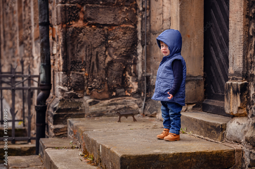 Young Child Exploring Historic Stone Steps in a Blue Hooded Vest