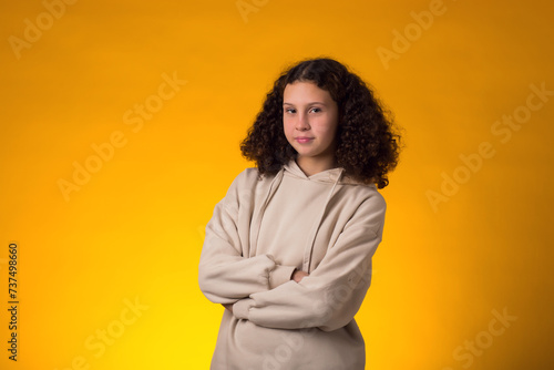 Smiling girl looking at camera over yellow background. Positive emotions concept © Aleksej