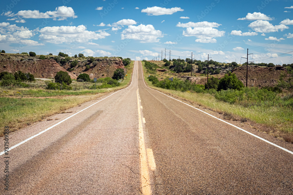Asphalt road through the desolate empty New Mexico landscape along Historic US Route 66, USA