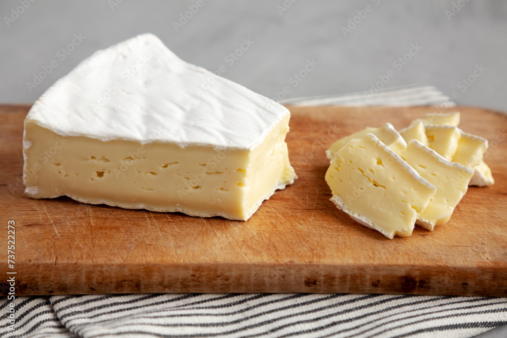 Organic Brie Cheese on a wooden board, side view.
