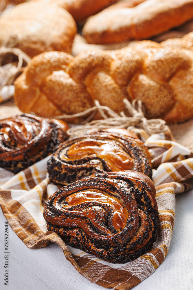 Closeup Buns with poppy seeds. Different types of artisan craft bread in bakery store shelves