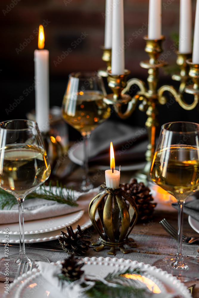 Rustic Scandinavian style zero waste eco-friendly dinner table decor for Christmas or new year family celebration. Wooden table, natural elements like pine cones, fir tree branches, candles