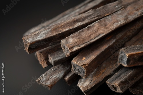 Close up view of oudh sticks on black background used for burning as incense or making Arabian oud oils or bakhoor photo