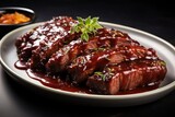 Grilled steak with melted barbeque sauce on a black and blur, Meat steak with sauce, on a white plate, on a black background Grilled beef tenderloin steak served on a black plate with demiglace sauce