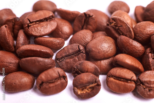 Macro of coffee beans on a white background. Background wallpaper. Roasted Arabica beans