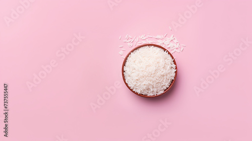 Bowl with boiled rice on pink background, top view. Space for text