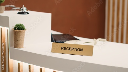 Close up of elegant modern stylish hospitality industry lounge hotel lobby check in desk. Empty welcoming resort lobby reception counter with concierge bell next to mini plant