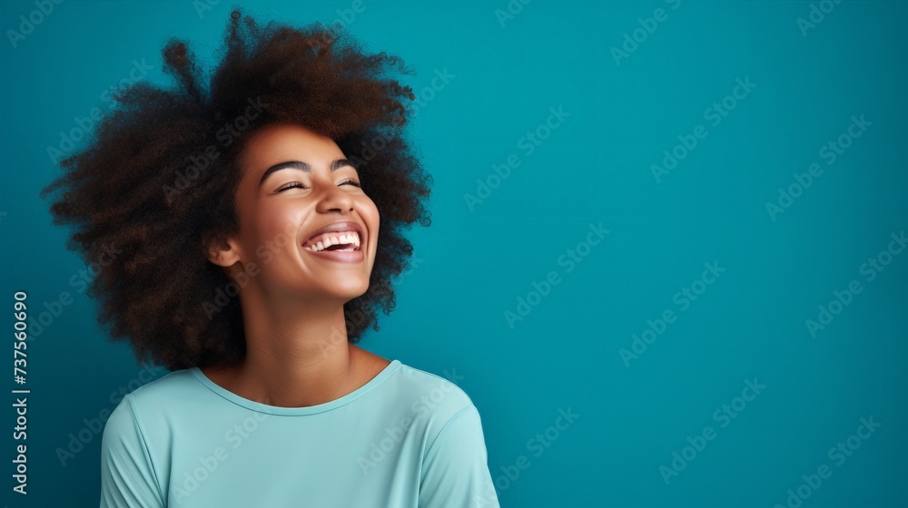 Portrait of happy young black woman laughing against blue wall Portrait of happy young black woman laughing against blue wall