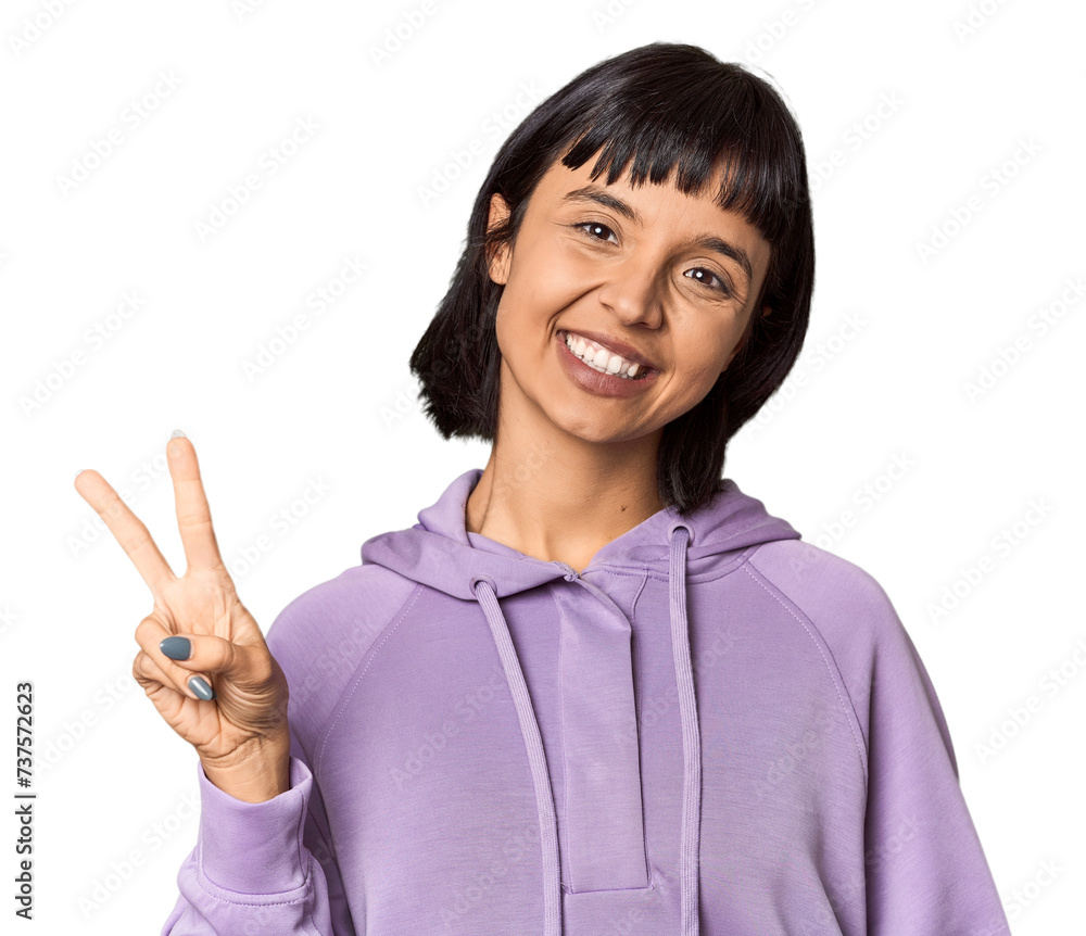 Young Hispanic woman with short black hair in studio joyful and carefree showing a peace symbol with fingers. Young Hispanic woman with short black hair in studio joyful and carefree showing a peace symbol with fingers.