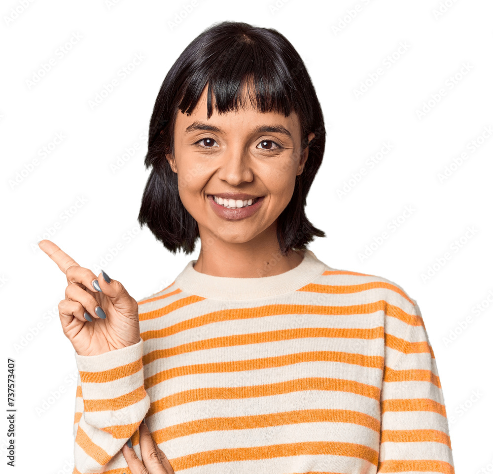 Young Hispanic woman with short black hair in studio smiling cheerfully pointing with forefinger away. Young Hispanic woman with short black hair in studio smiling cheerfully pointing with forefinger away.