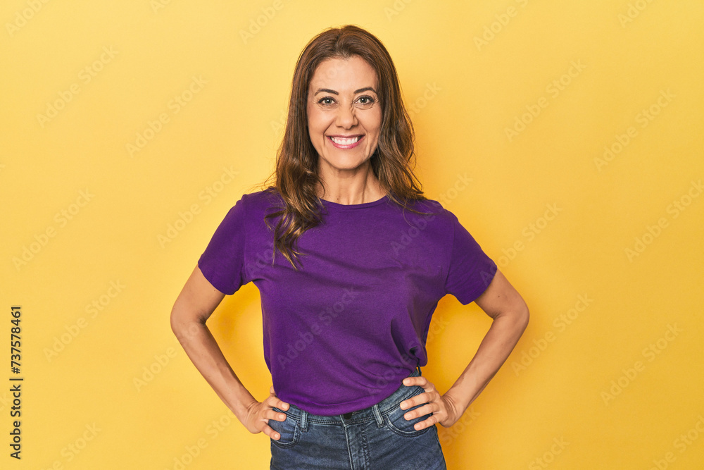 Middle-aged caucasian woman on yellow confident keeping hands on hips. Middle-aged caucasian woman on yellow confident keeping hands on hips.