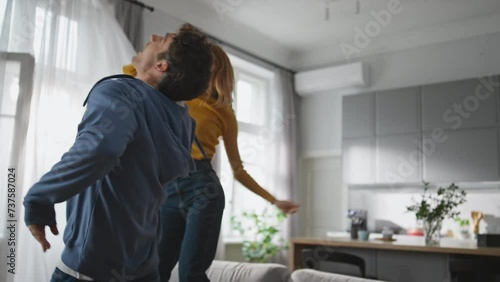 Happy husband wife jumping sofa in luxury house closeup. Carefree couple dancing photo