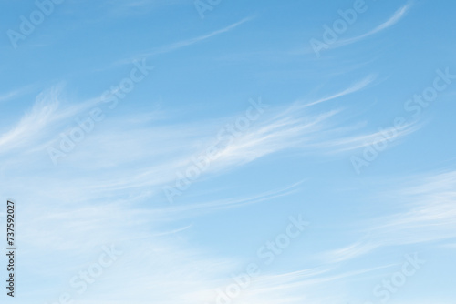 Light ethereal white clouds high in a sunny blue sky, as a nature background 