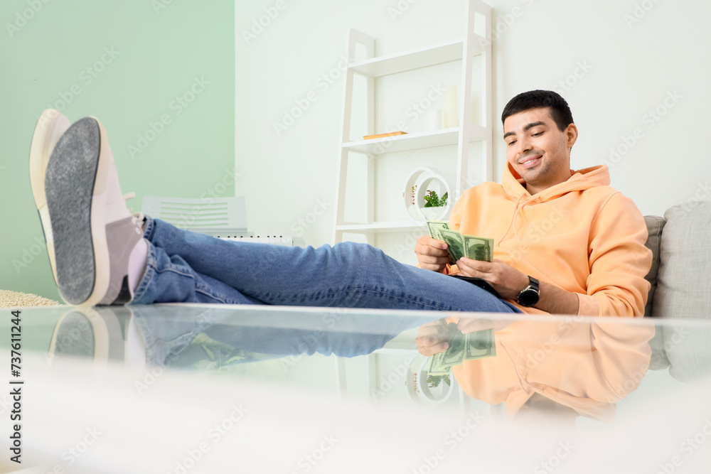 Young man with money at home